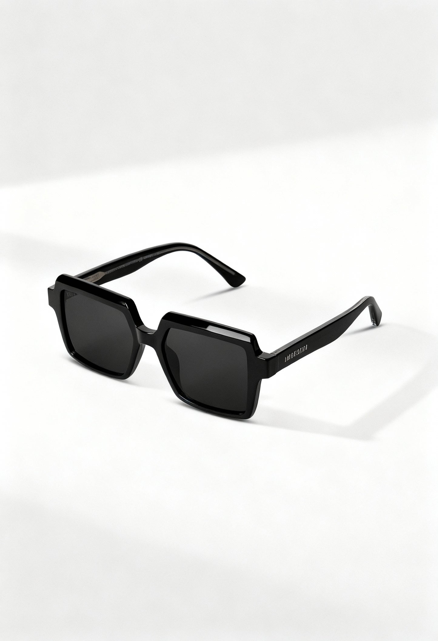 LatenzaZero Echelon unisex sunglasses with black acetate frame and square UV3 lenses, displayed on a white surface under natural light.