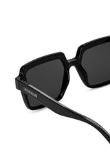 Close-up detail of LatenzaZero Echelon sunglasses showing glossy black acetate frame and UV3 protective lenses.