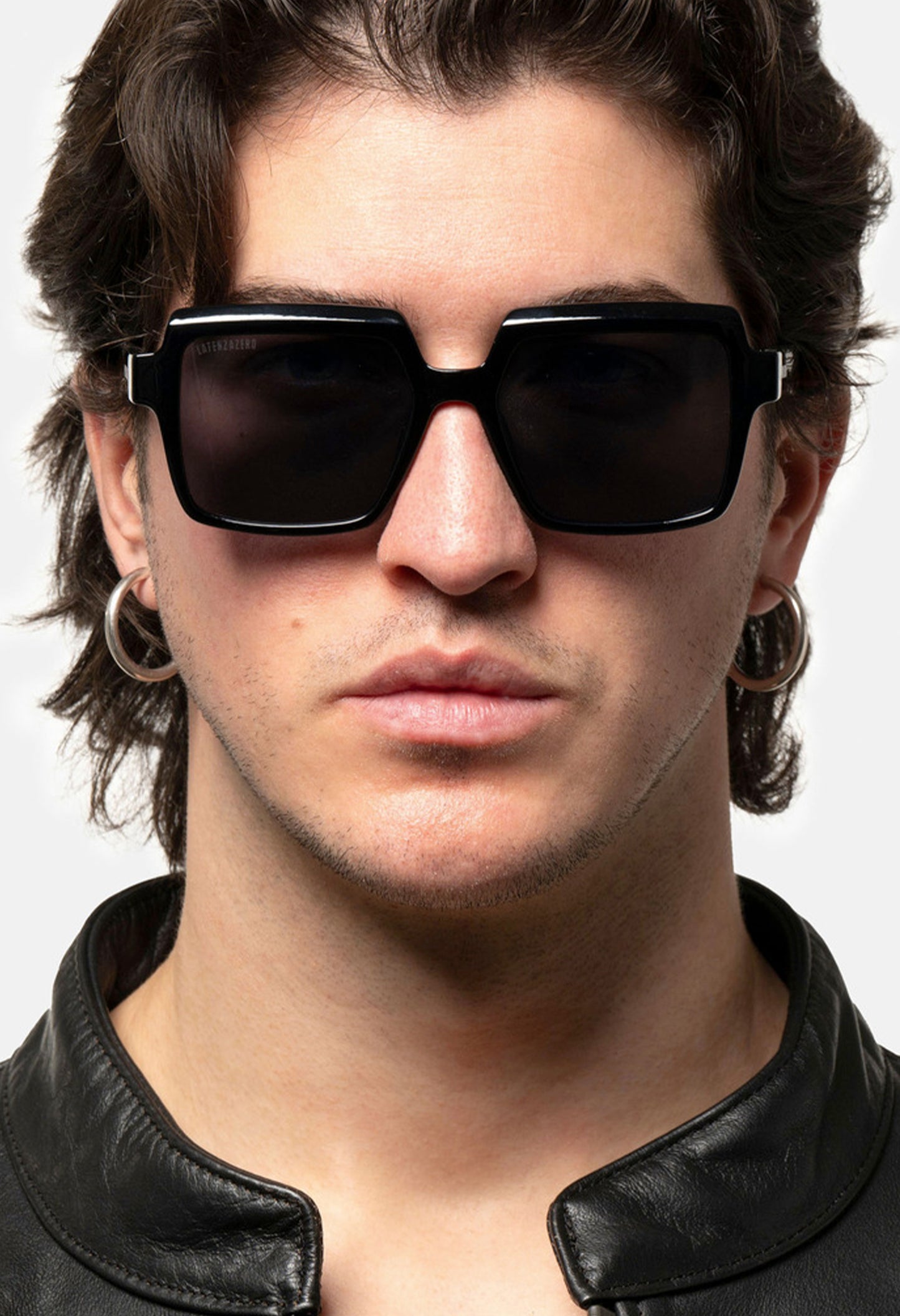 Male model wearing LatenzaZero Echelon sunglasses with black acetate frame and square UV3 lenses, confident urban look.