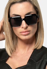 Close-up of woman wearing LatenzaZero Echelon sunglasses, showcasing black acetate frame and UV3 lenses with modern elegance.