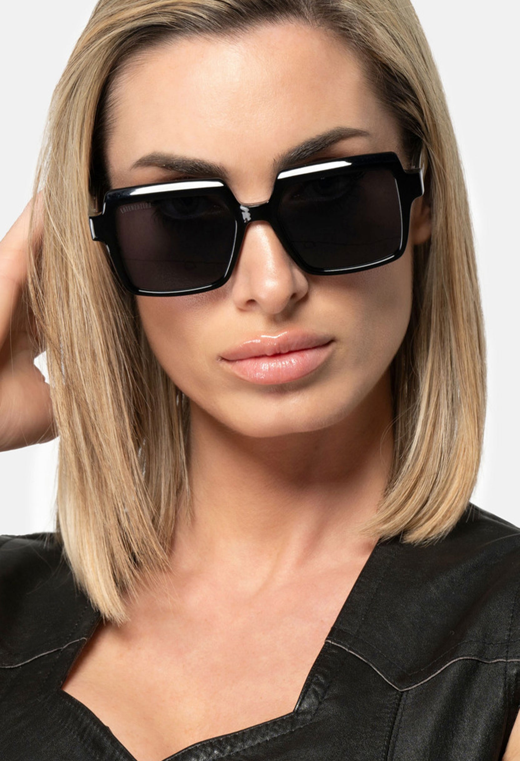 Close-up of woman wearing LatenzaZero Echelon sunglasses, showcasing black acetate frame and UV3 lenses with modern elegance.