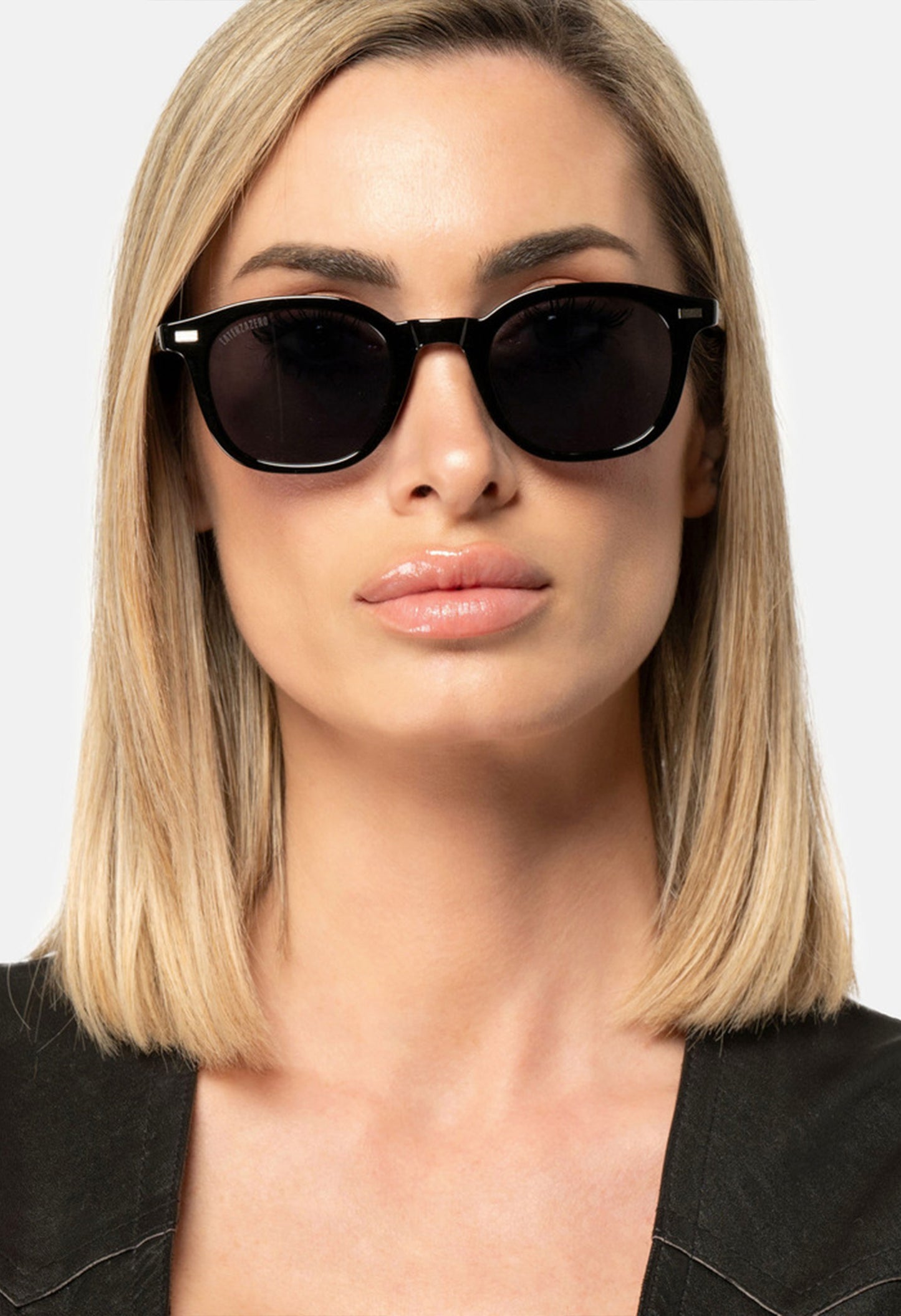Portrait of woman wearing LatenzaZero Zenith black sunglasses, UV3 lenses, showcasing classic unisex luxury style.