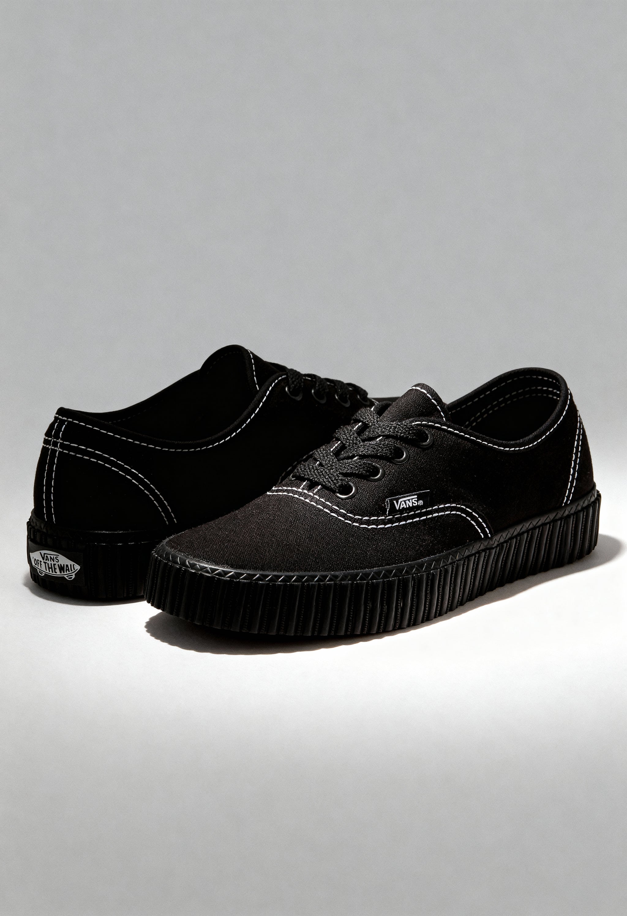 Black Vans VN000CR2BLK1 unisex sneakers displayed in studio lighting with canvas upper and rubber sole.