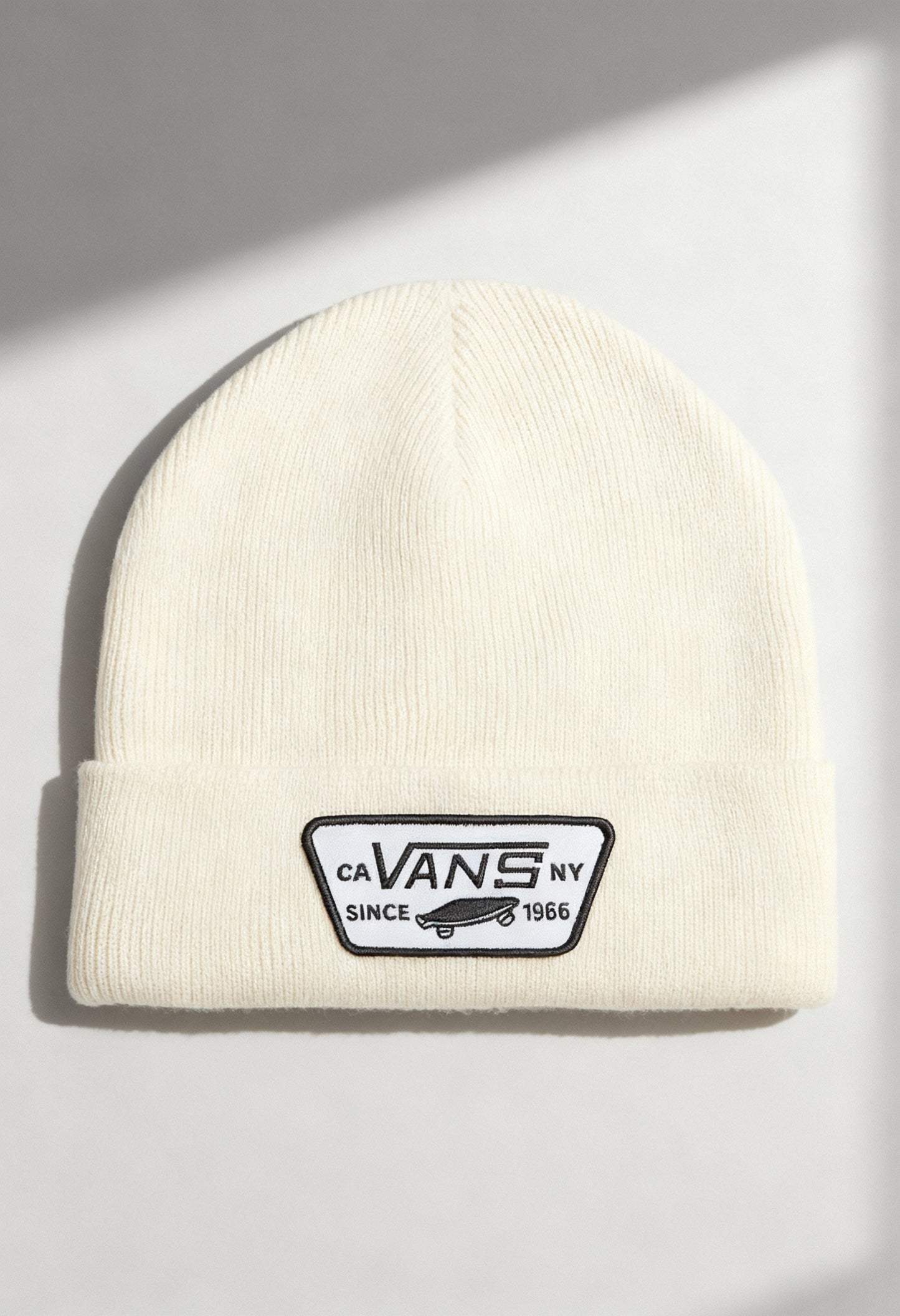 Vans VN000UOUDJR1 cream unisex beanie hat with fold-over cuff and Vans logo patch, shown in studio lighting.