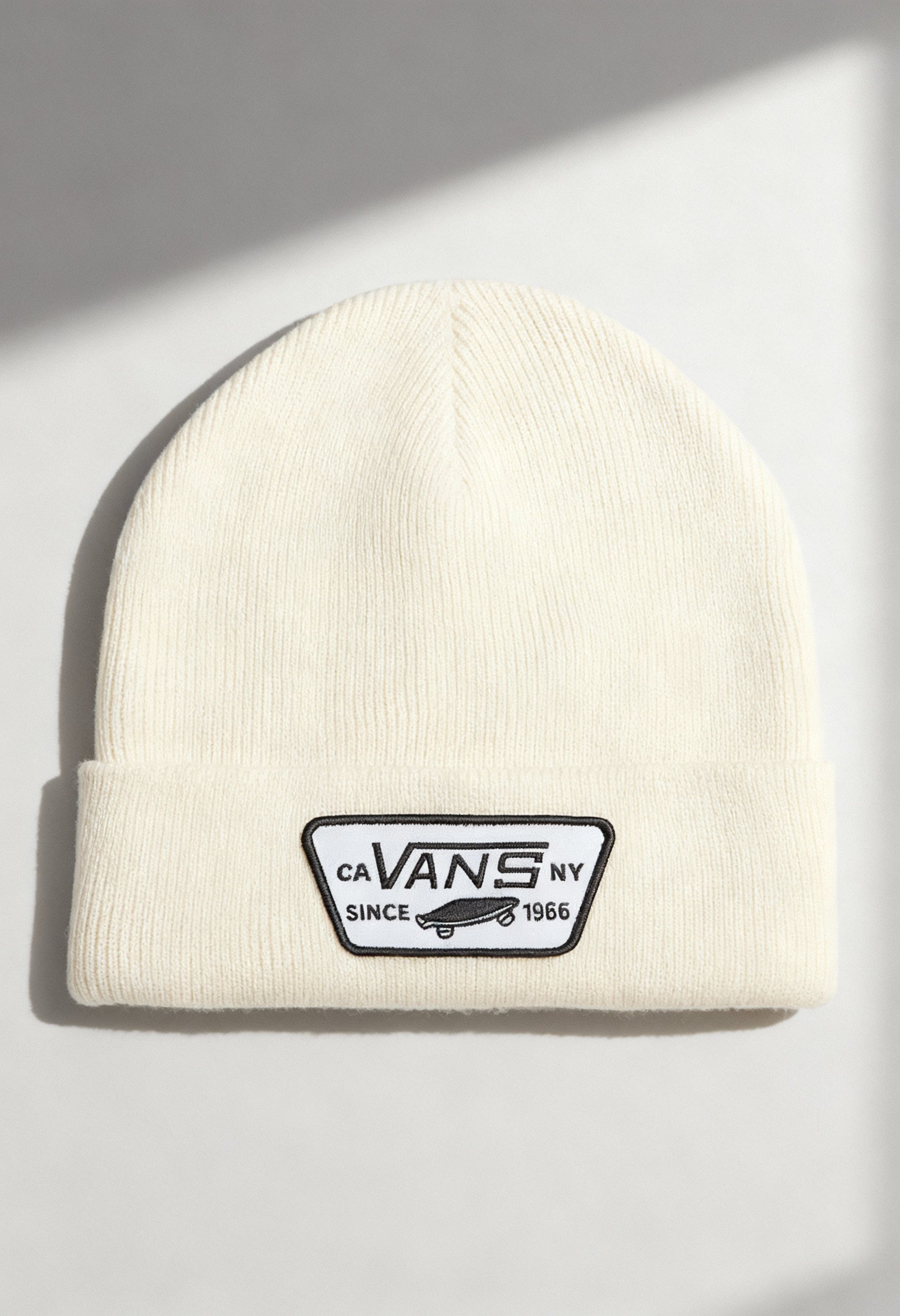 Vans VN000UOUDJR1 cream unisex beanie hat with fold-over cuff and Vans logo patch, shown in studio lighting.
