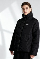 Woman wearing Vans VN0A7YK5BLK1 black bomber jacket with padded design and visible logo, front studio shot.
