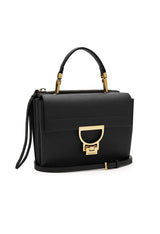 Side profile of an authentic Coccinelle designer handbag showing grained leather texture.