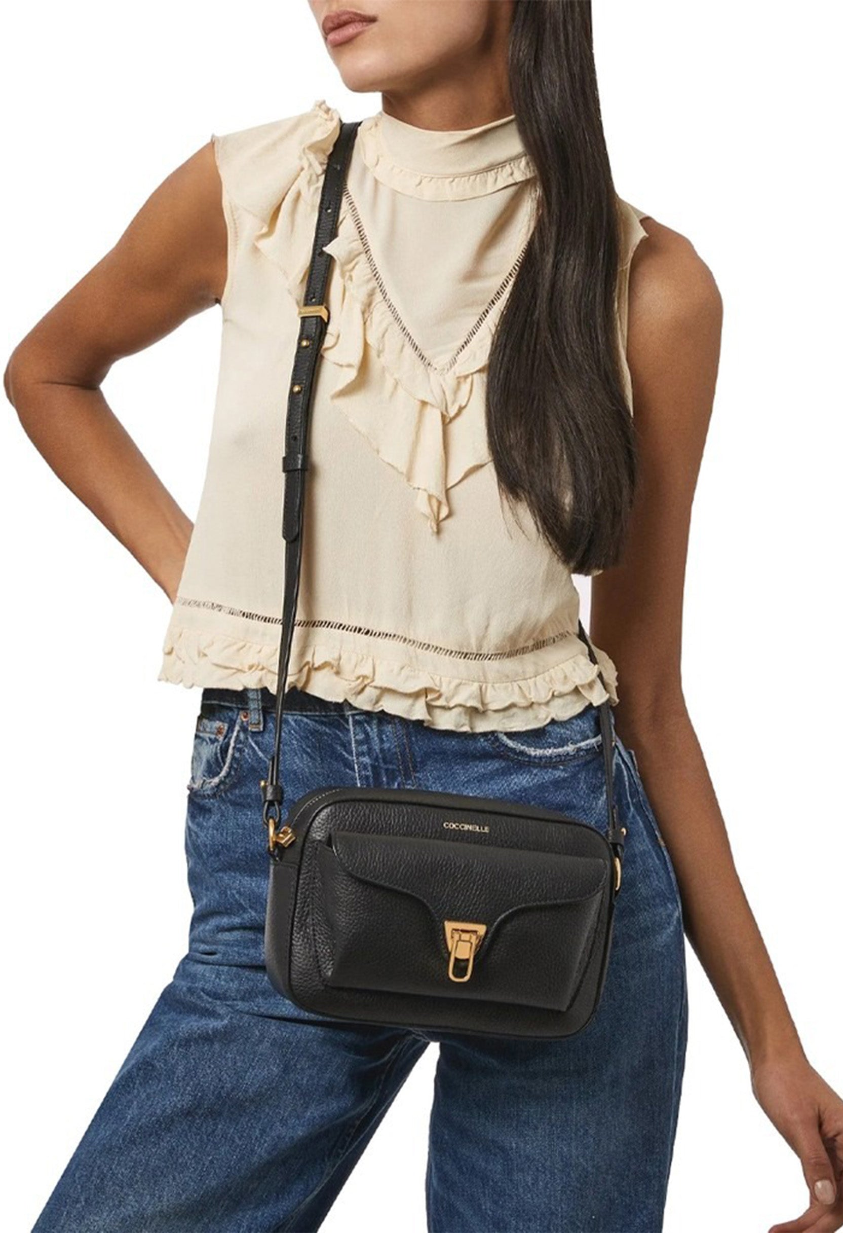 Coccinelle leather bag worn by model, showing size and adjustable strap.