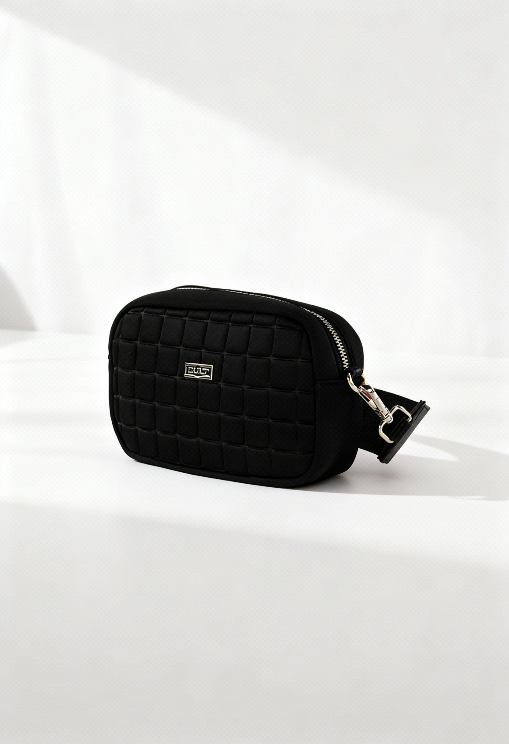 Front angle of the black Cult quilted across-body bag with zip closure and structured shape.