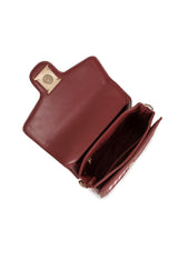 Open interior view of the burgundy Alison handbag showing compartments and magnetic closure.