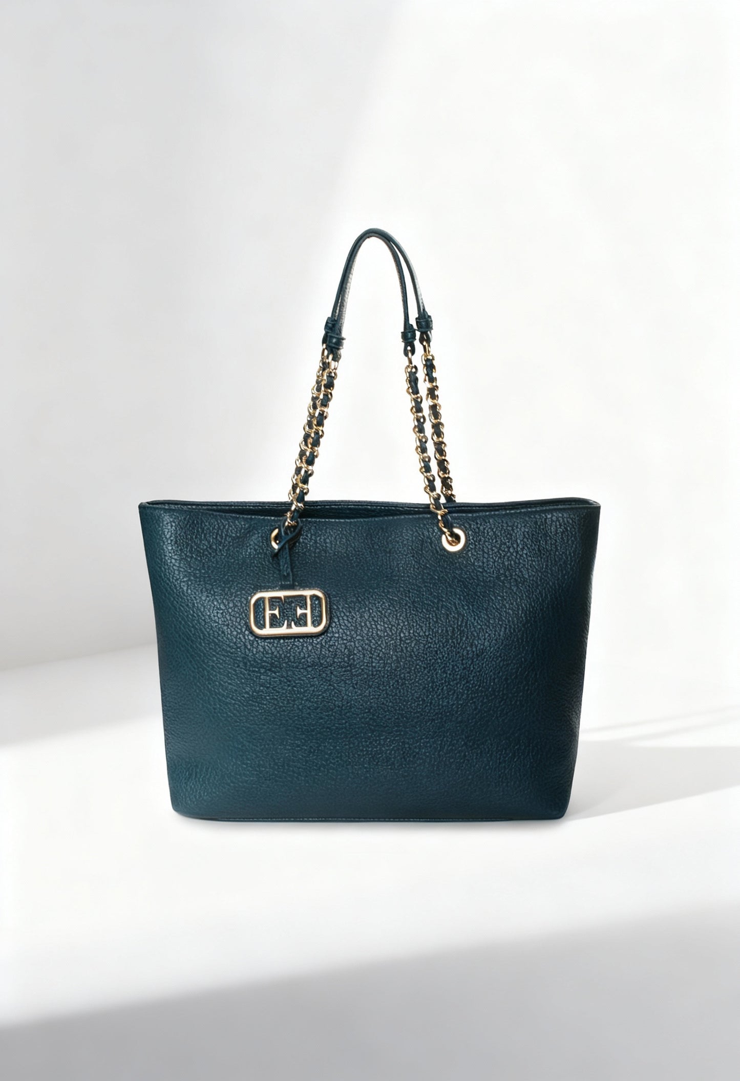 Front view of the dark teal Noemi woman shoulder bag with chain handles on a light background.