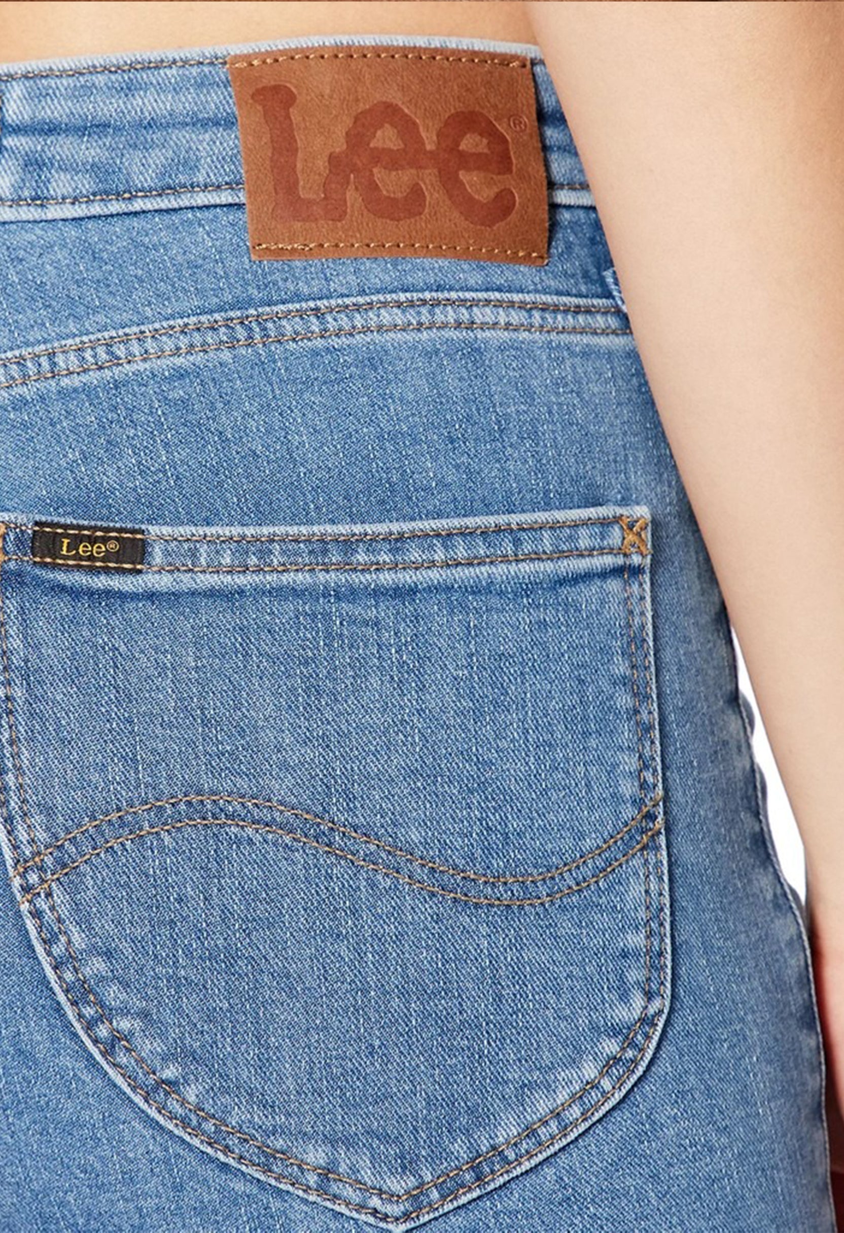 Close-up detail of the stitching and logo patch on the light blue Lee L626FAB38 skinny jeans.