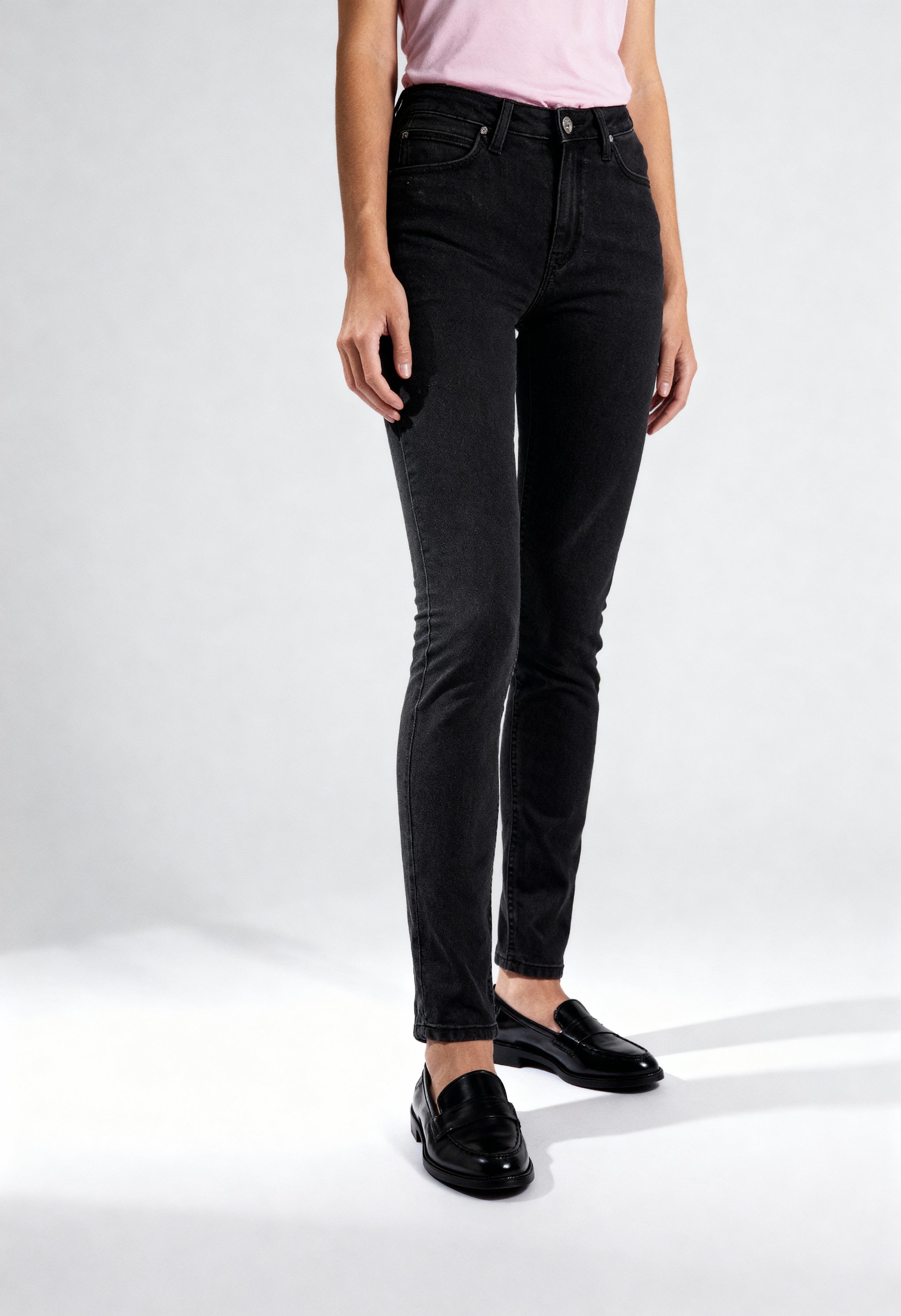 Front angled view of a woman wearing black Lee L626SHMY skinny jeans on a light background.