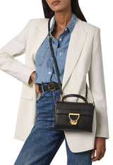 Black designer crossbody bag styled with a modern outfit from France AJ Luxe.