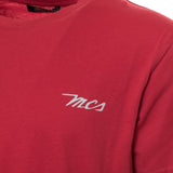 Close-up detail of the visible MCS logo embroidery/print on the t-shirt chest.