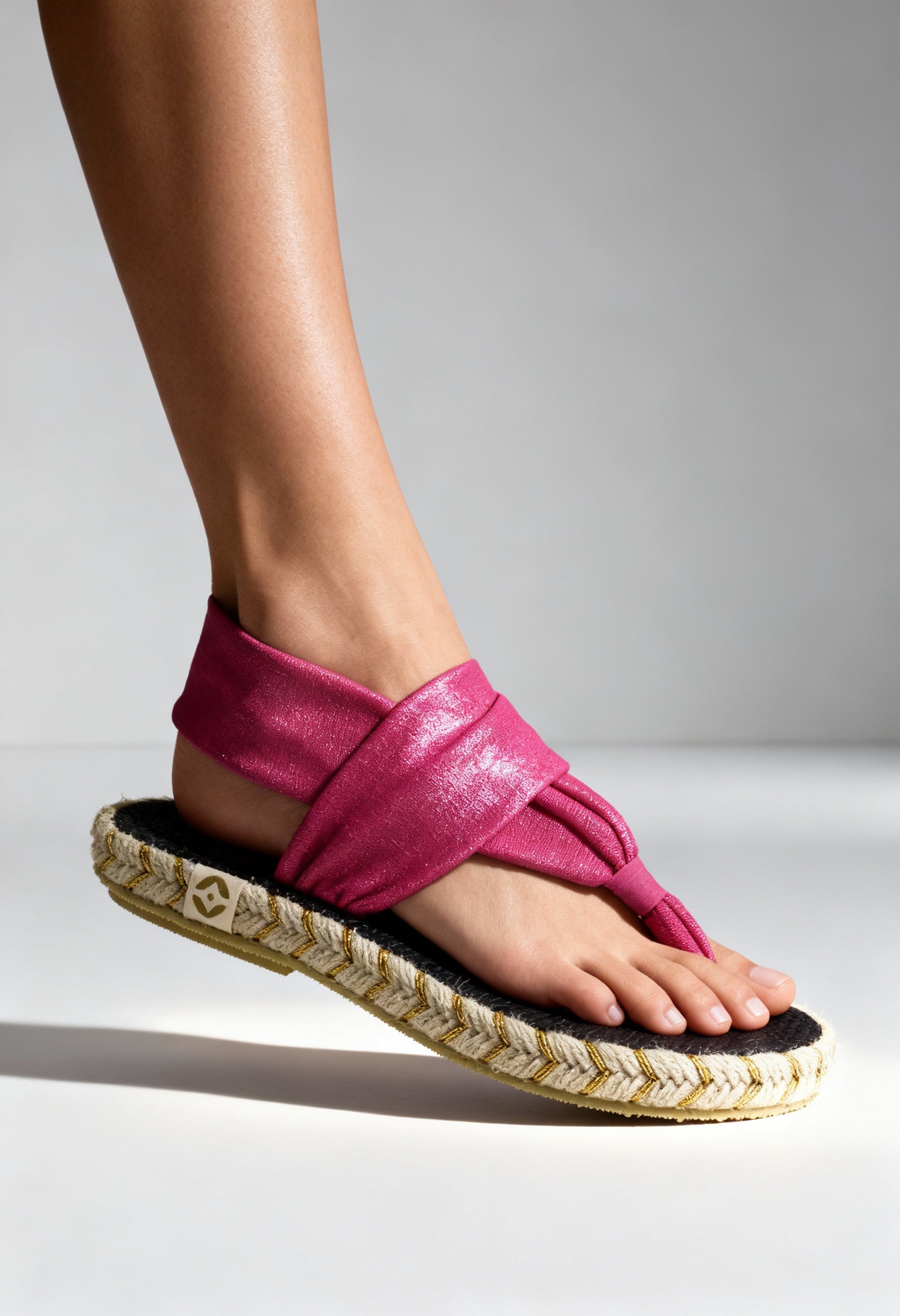 On-foot view of the pink Nalho cross-strap flip-flop sandals with braided sole and cushioned footbed.