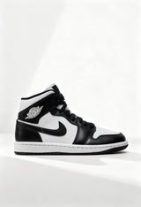Brand new Nike Air Jordan 1 Mid women's sneakers in black and white side view.