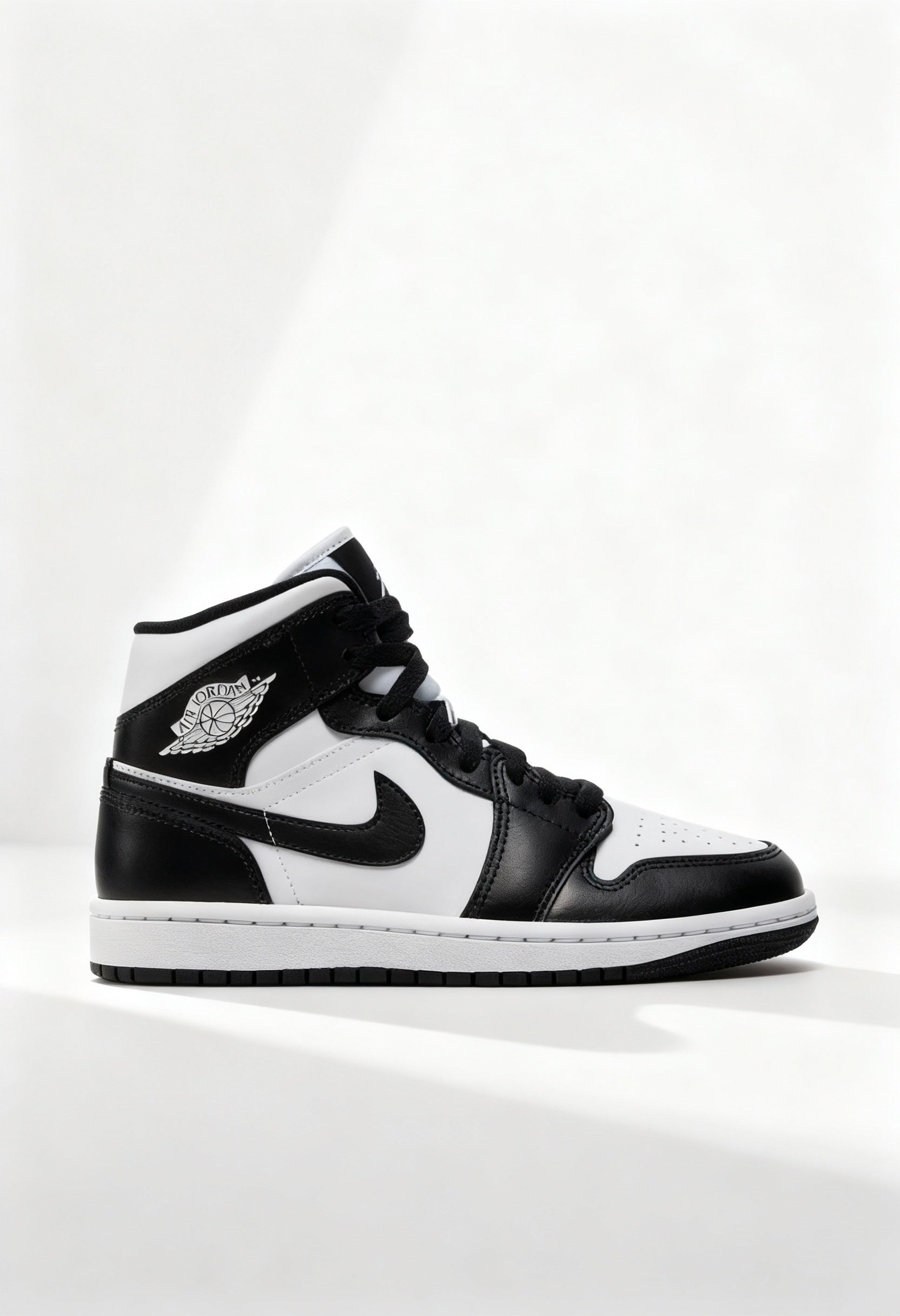 Brand new Nike Air Jordan 1 Mid women's sneakers in black and white side view.