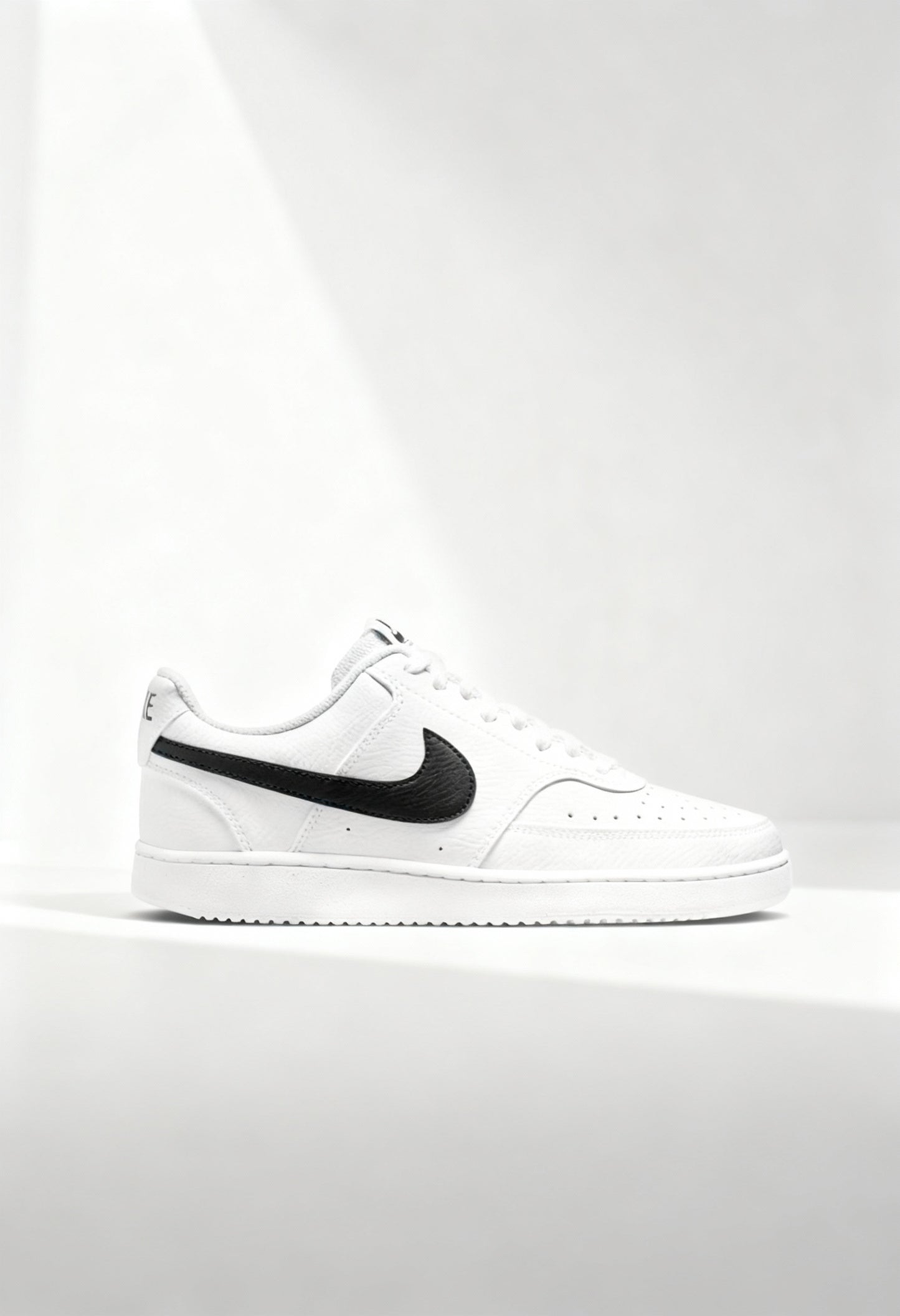 Brand new Nike Court Vision Low men's sneakers in white with a black Swoosh side view.