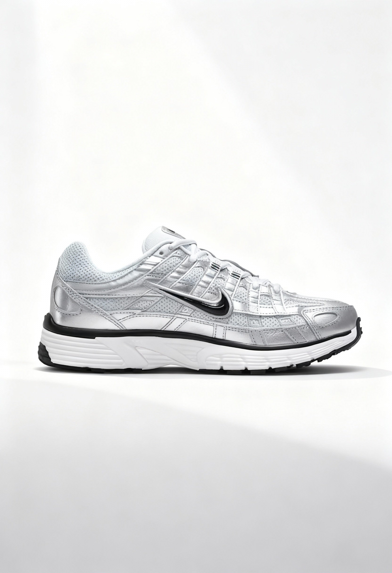 Brand new Nike P-6000 women's sneakers in metallic silver and white side view.