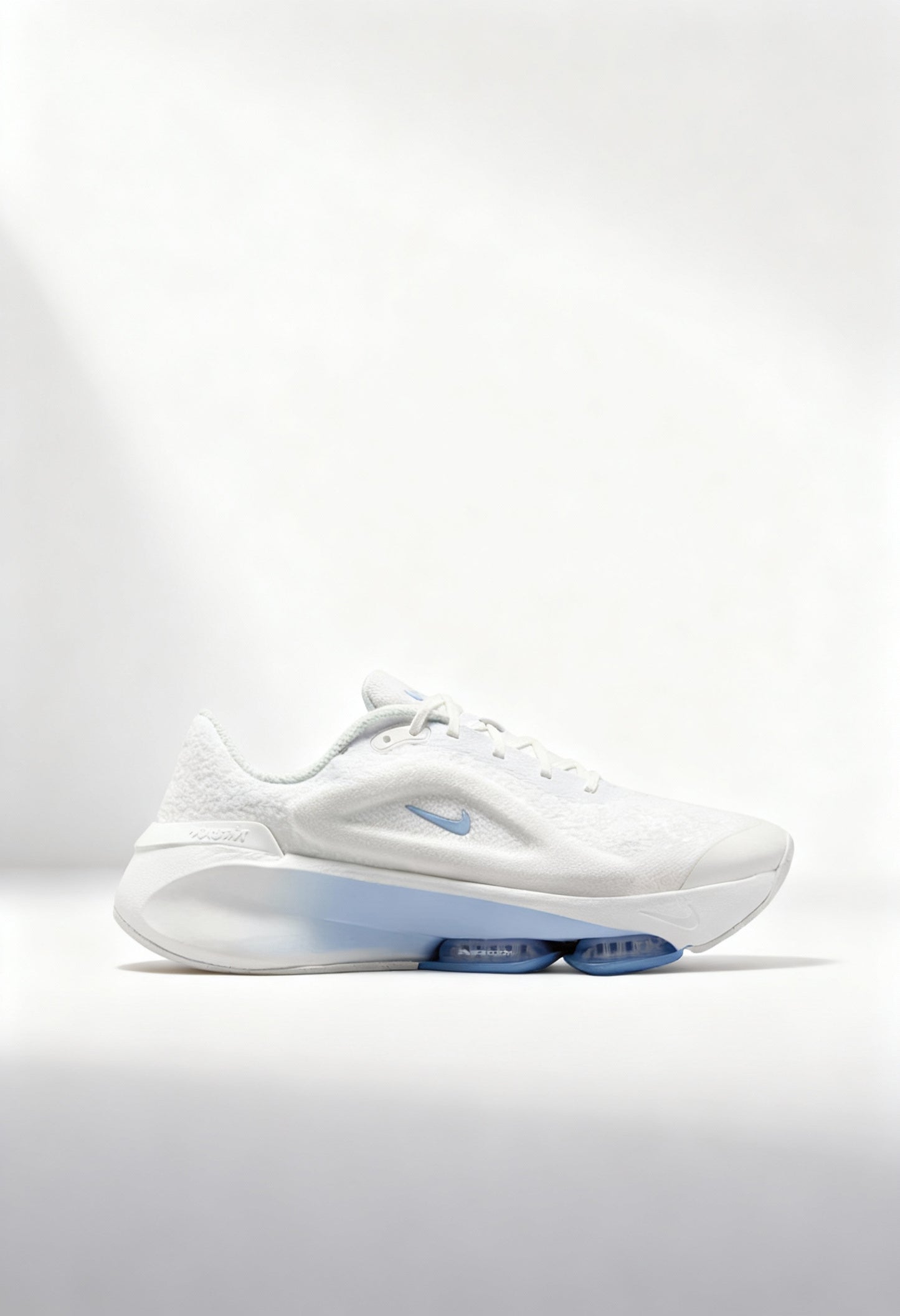 Brand new Nike Versair women's training shoes in white with a blue Zoom Air unit side view.