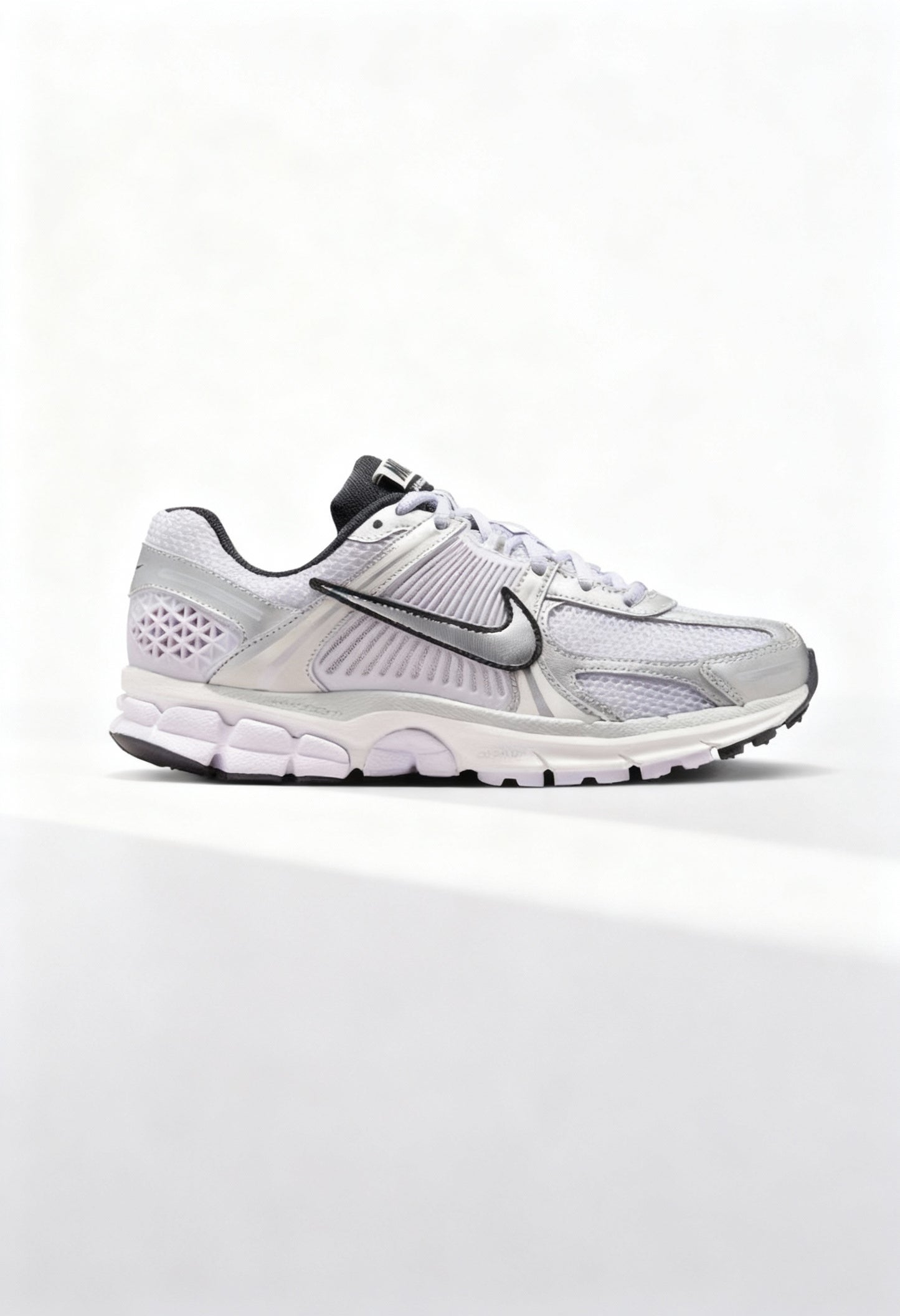 Brand new Nike Zoom Vomero 5 women's sneakers in silver and white side view.