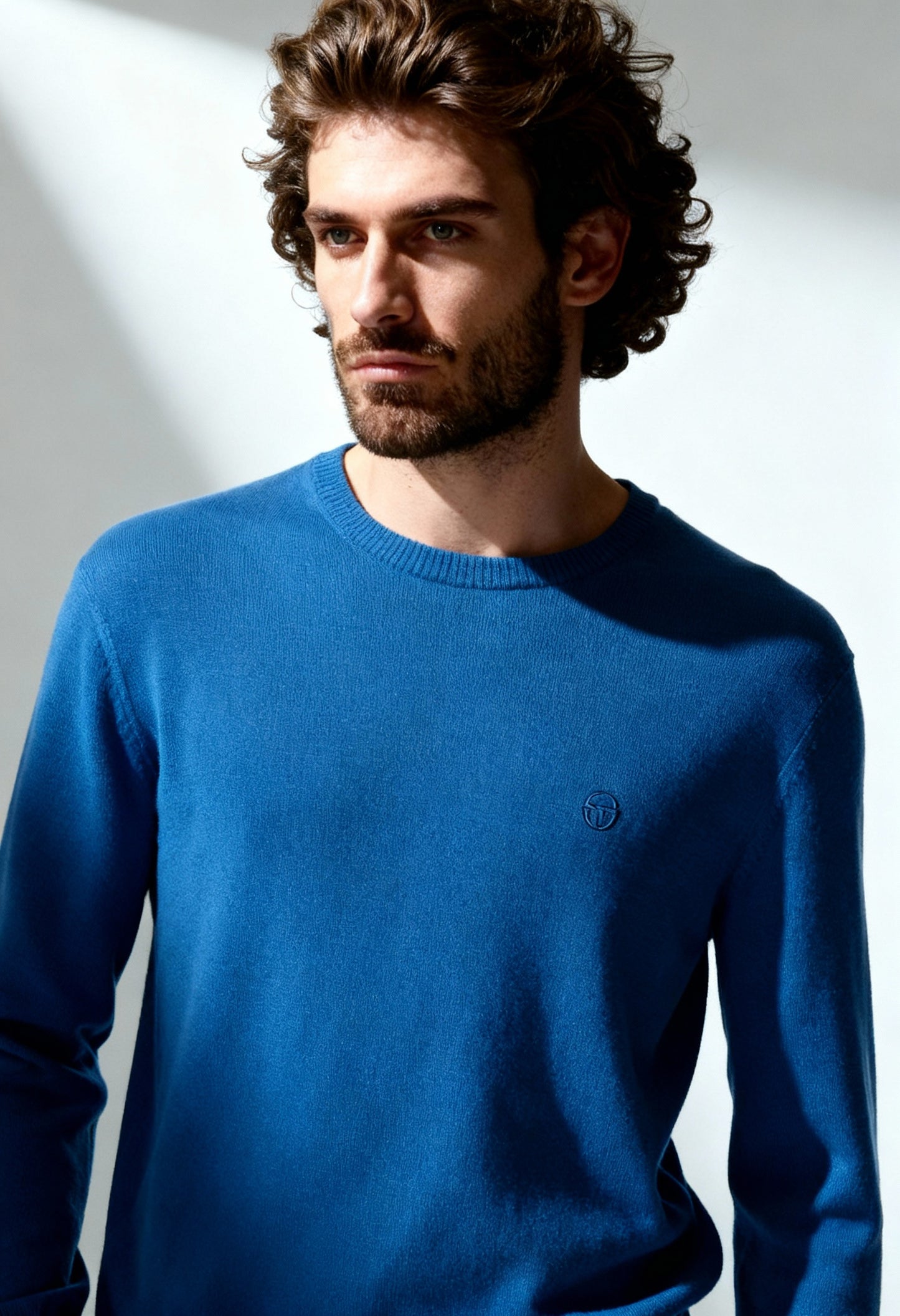 Sergio Tacchini men's cotton wool blend sweater in blue, worn by model, showing round neckline.