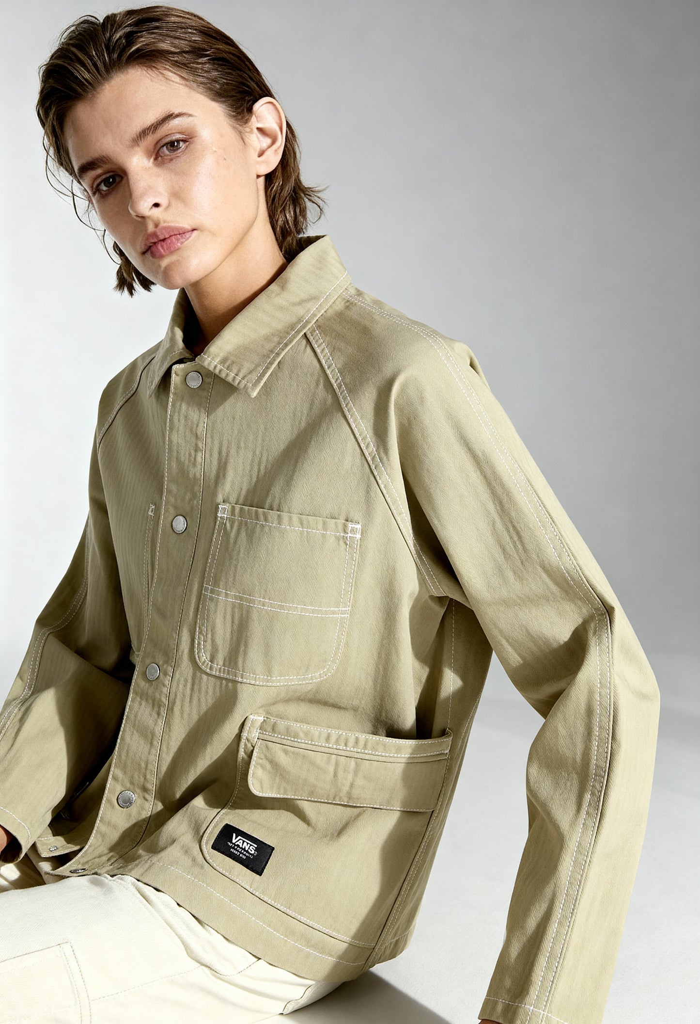 Studio front shot of a woman wearing the beige Vans VN000HJRD3Z1 cotton jacket.